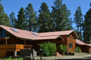 A large wooden house with a red roof.