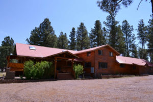 A large wooden house with a red roof.